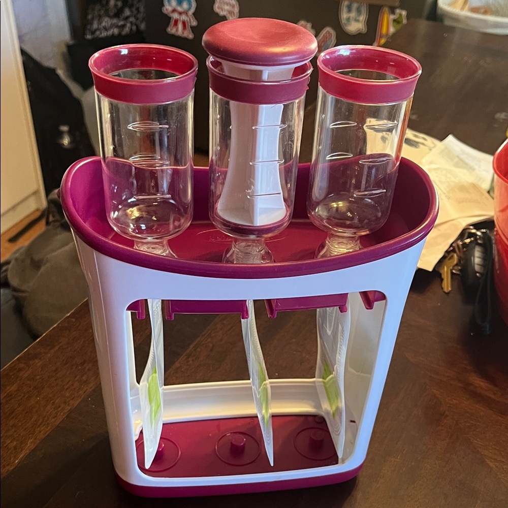 Purple and white squeeze station, baby food pouch filler